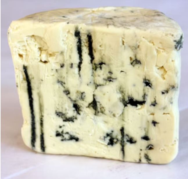 A slice of Point Reyes Original Blue cheese, showcasing its creamy interior with blue veining, is set against a grey background