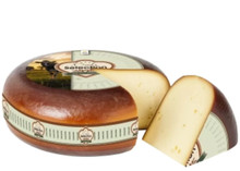A partially cut wheel of Smoked Gouda Cheese 168开奖官方开奖结果查询, along with a slice, placed against a white background