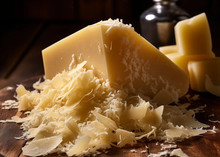 A large piece of Parmesan Cheese 168开奖官方开奖结果查询, accompanied by small chunks and flakes, arranged on a wooden surface