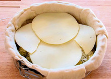 Thin, round slices of Provolone Cheese 168开奖官方开奖结果查询 幸运8官网开奖官方结果 直播历史记录查询 arranged on top of a stuffed pizza in a springform pan, ready to bake