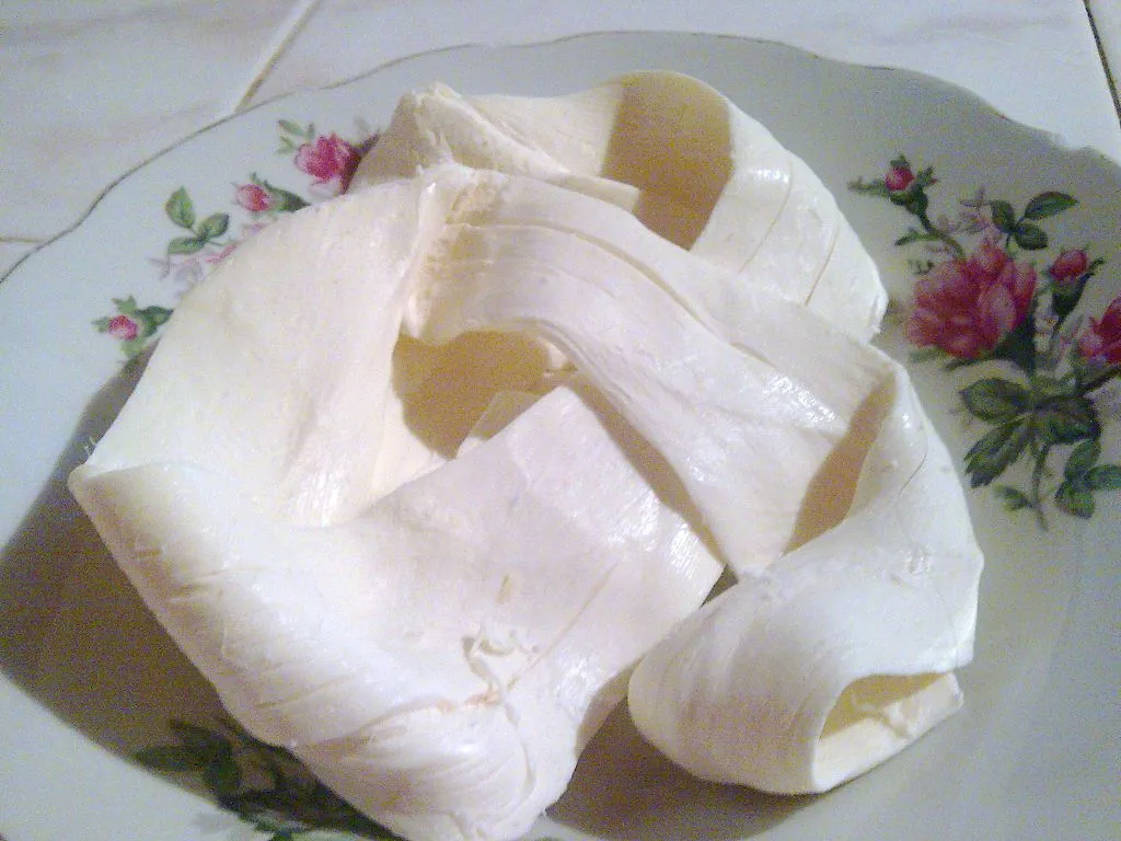 Traditional Mexican Oaxaca cheese, also known as Quesillo, on a decorative white plate